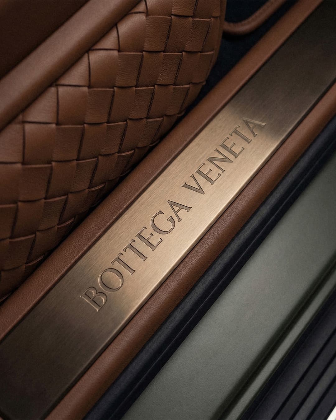 Dettaglio di una borsa intrecciata Bottega Veneta con placca in metallo incisa
